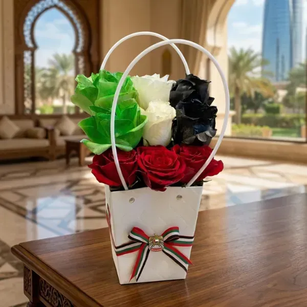UAE National Day flowers arrangement with green white black and red roses in white handle gift bag